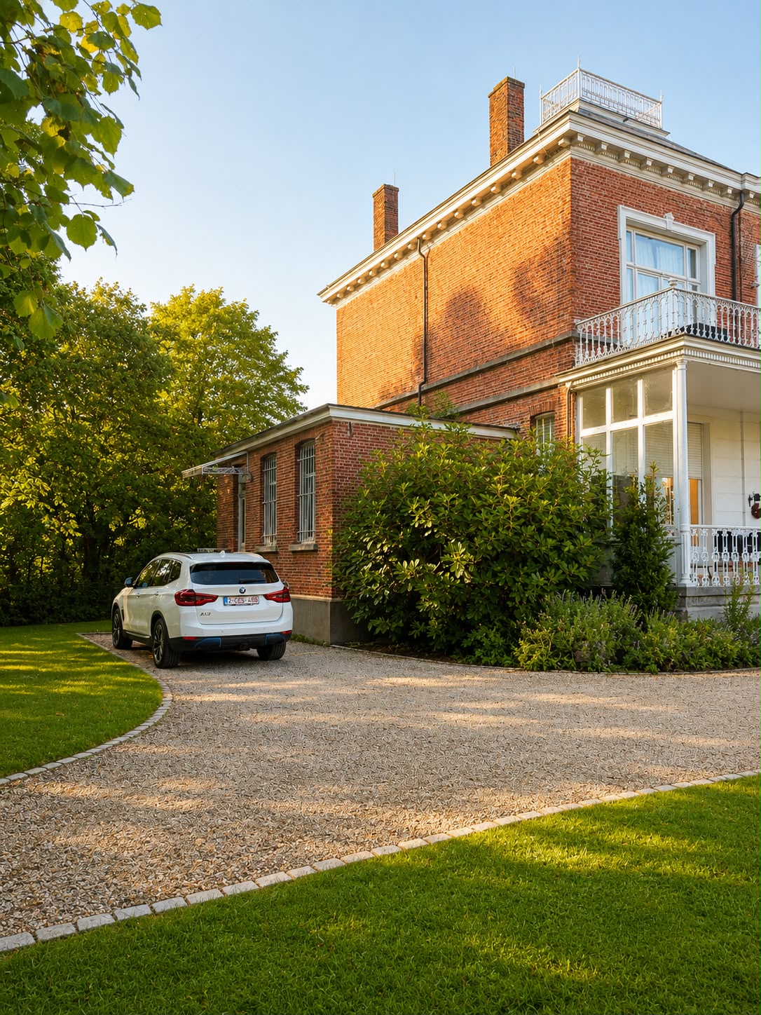 Zijgevel van de villa met oprit en veranda