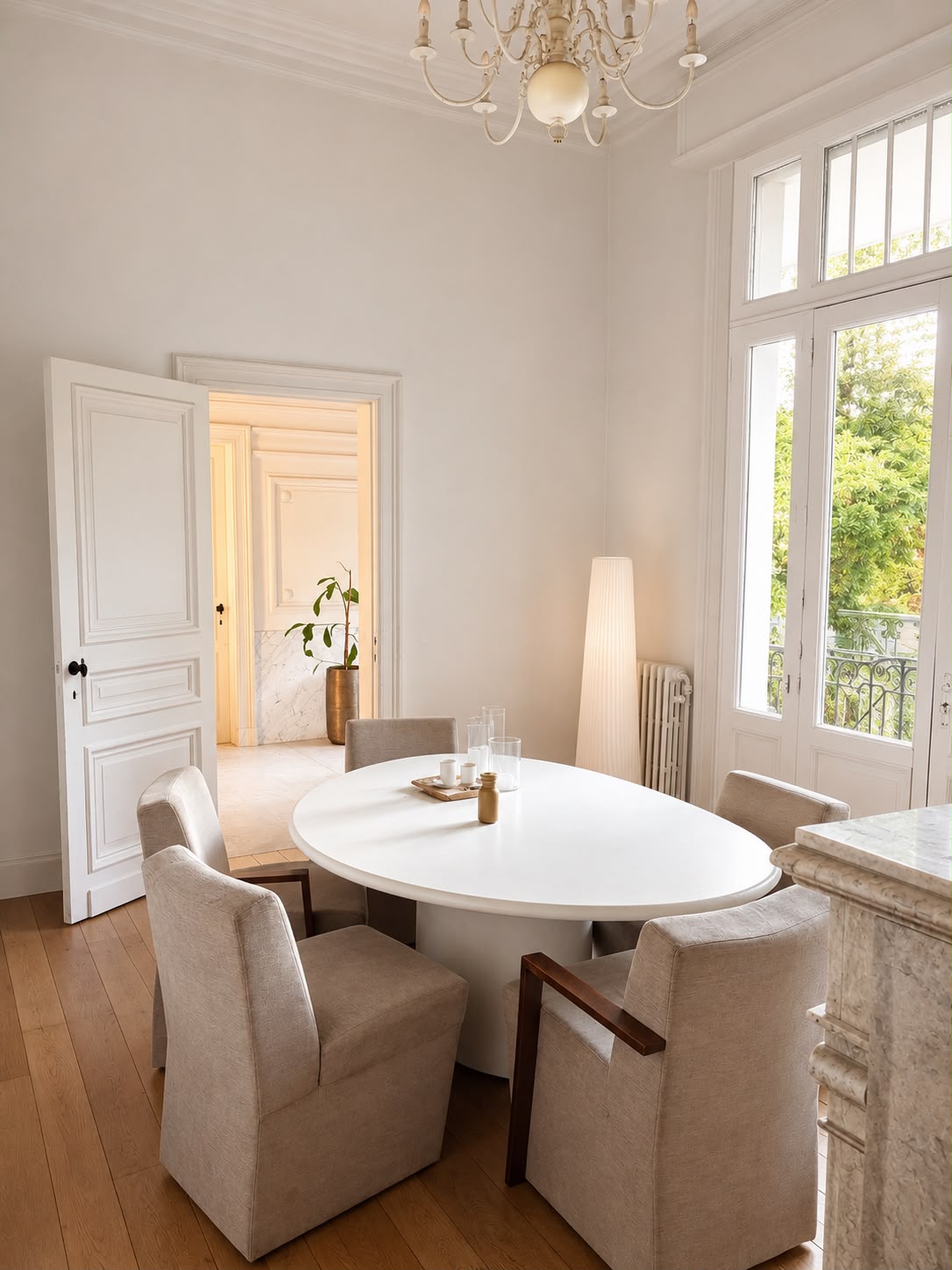 Eetkamer met ovale tafel, luchter en openslaande tuindeuren