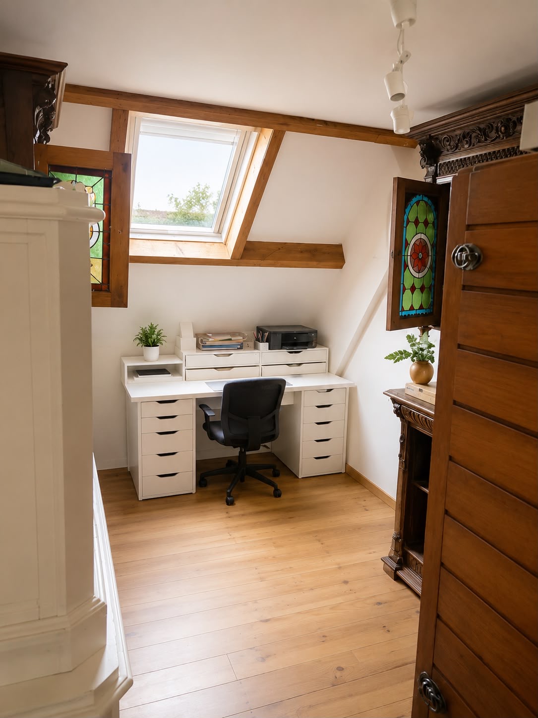 Bureau onder het dak met glas-in-loodraampjes