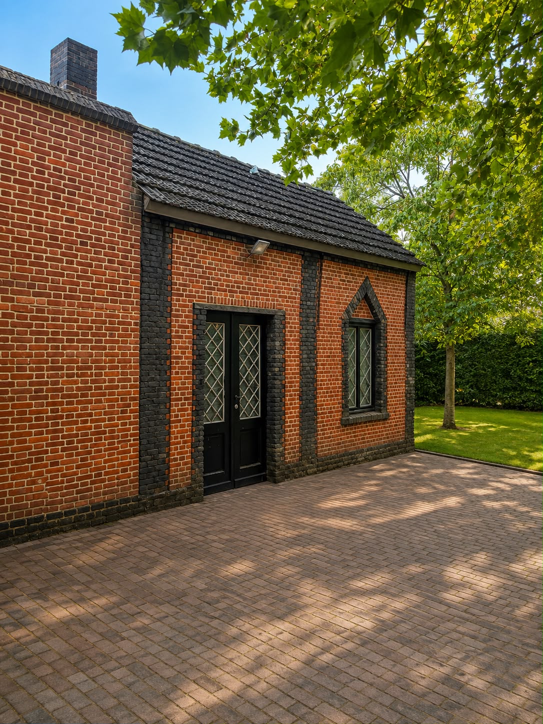 Bijgebouw in rode baksteen met zwarte deur