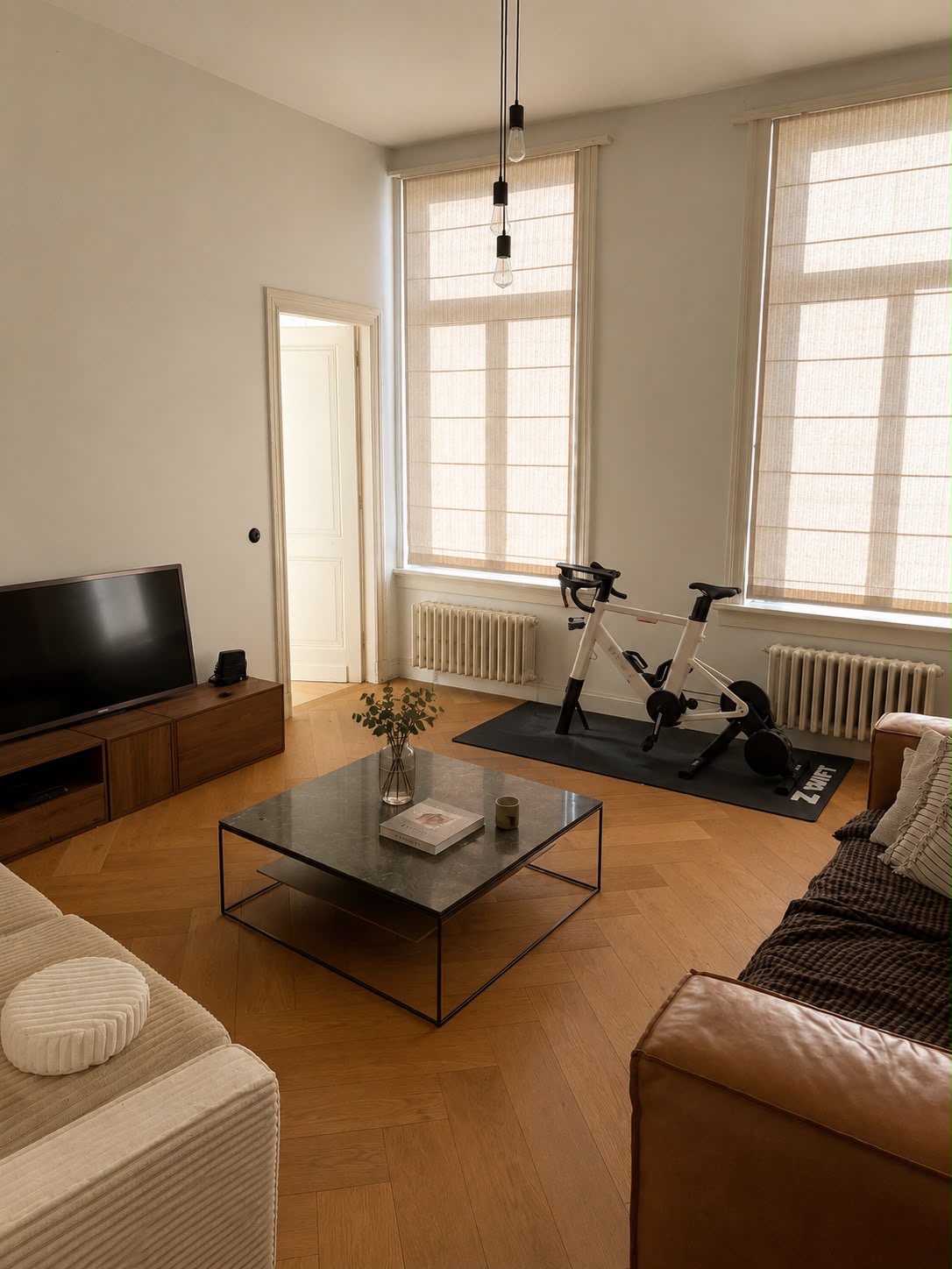 Tv-ruimte met hoge ramen en visgraatparket